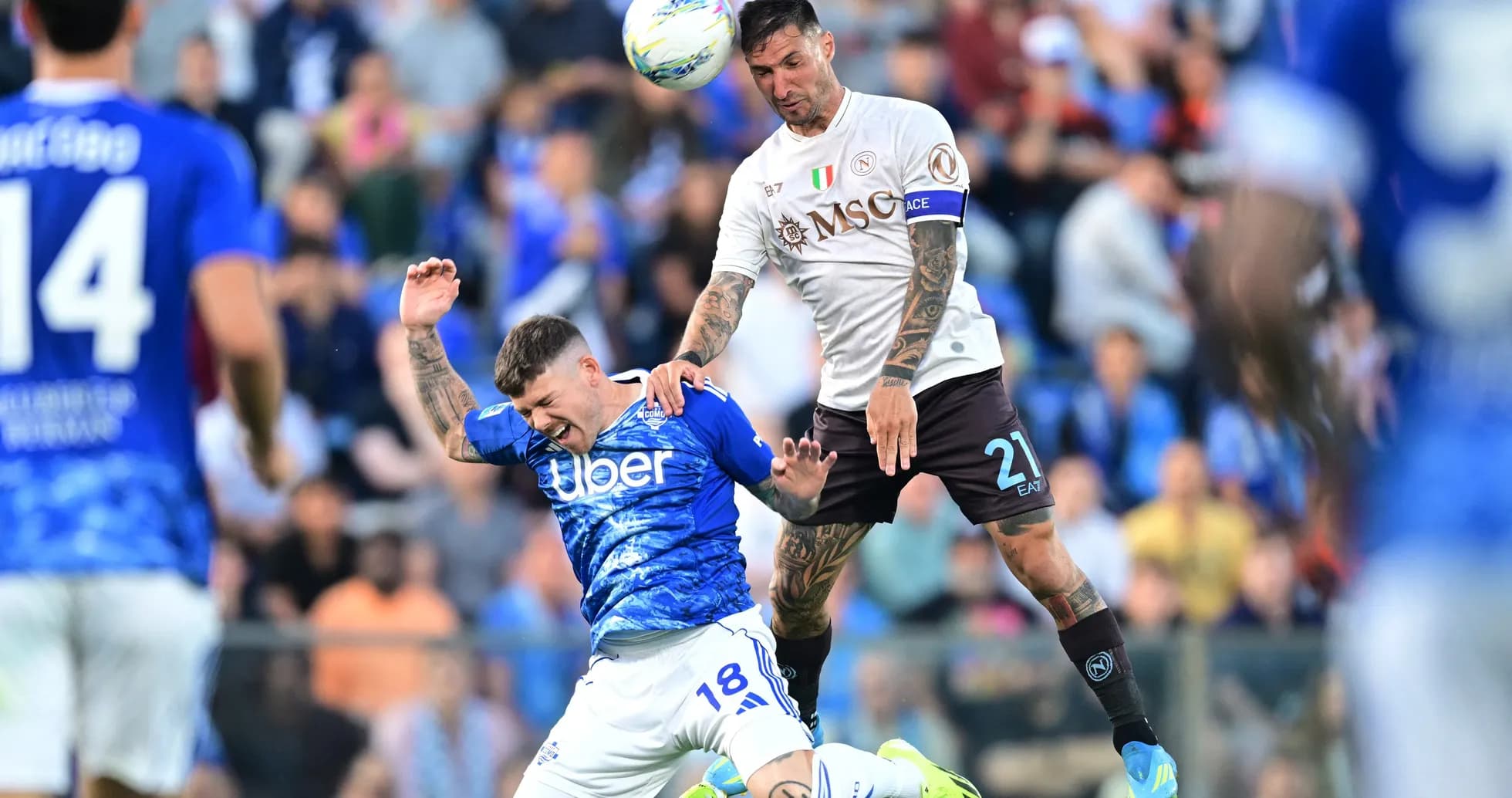 Napoli player challenging Como player in mid-air