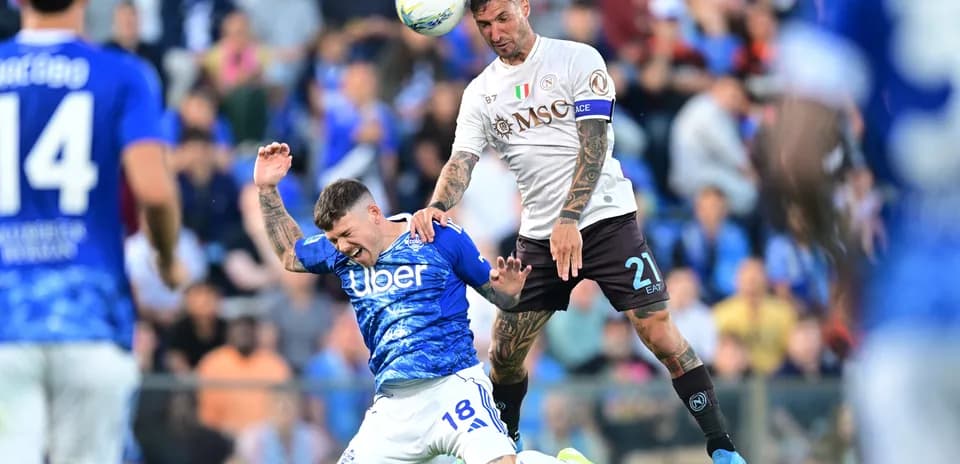 Napoli player challenging Como player in mid-air