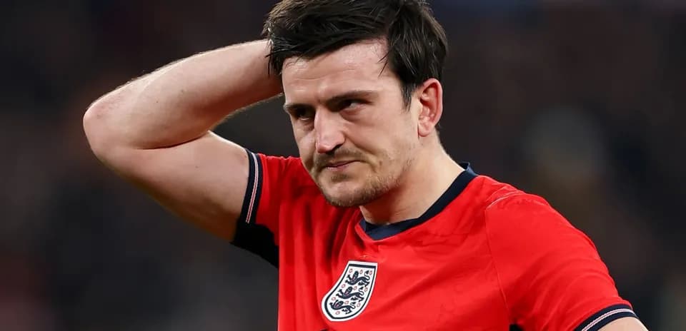 Player in red jersey with England crest, looking concerned