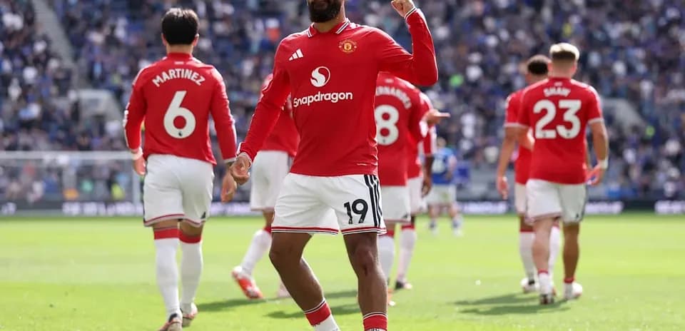 Player celebrating a goal with teammates in stadium