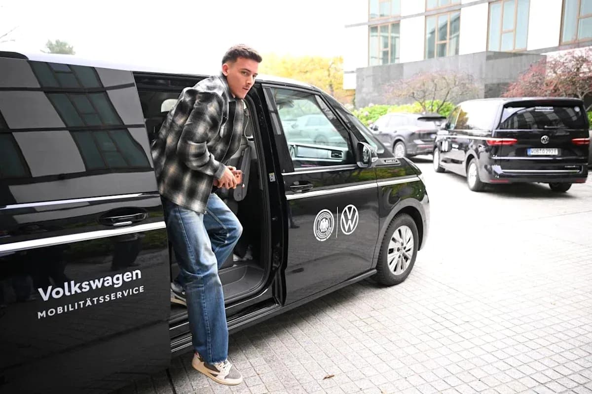 Player exiting Volkswagen vehicle at training location