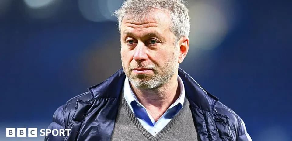 Man in a coat standing in a stadium