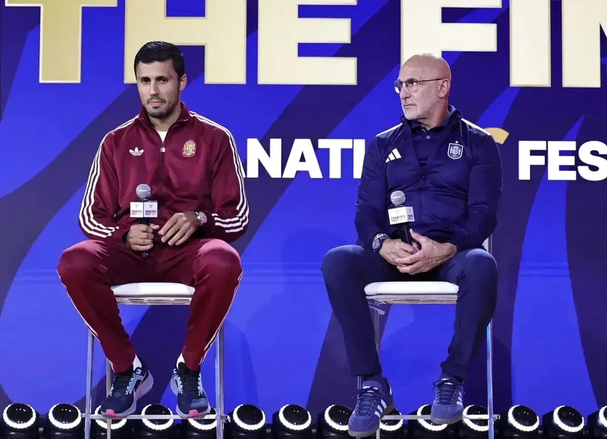 Two coaches seated at press conference with microphones