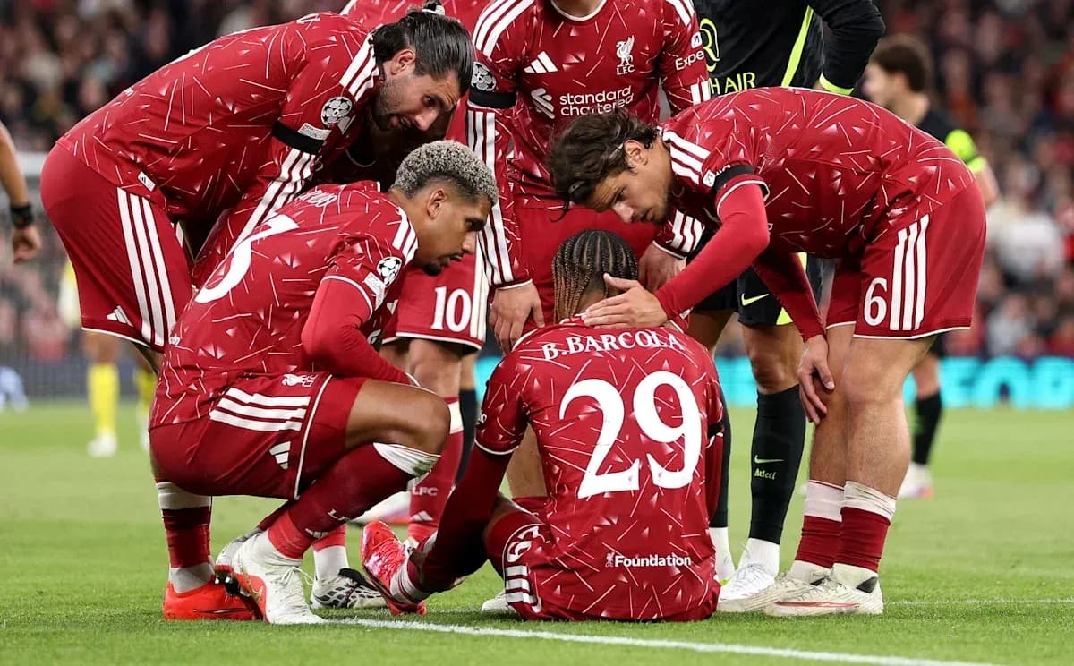 Liverpool players supporting teammate on the pitch