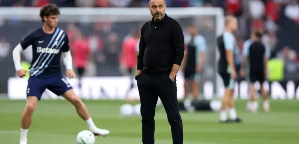 Coach observing players during warm-up on pitch