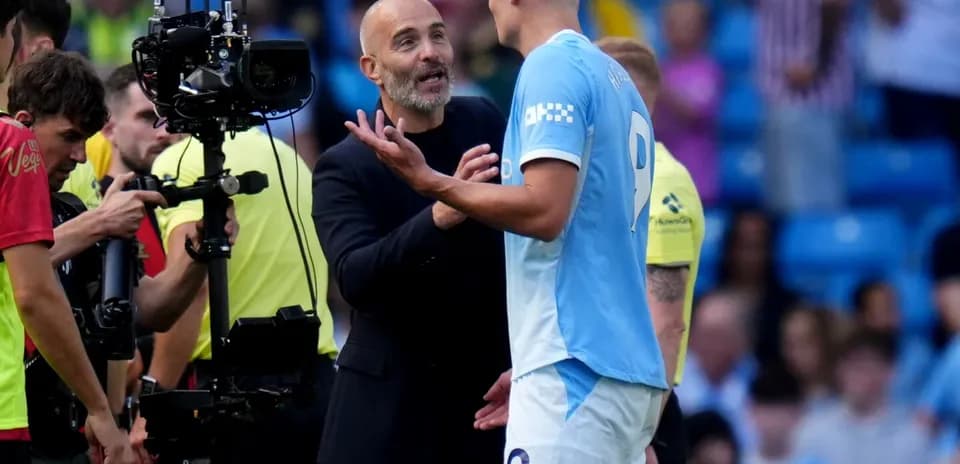 Manager discussing strategy with player on pitch