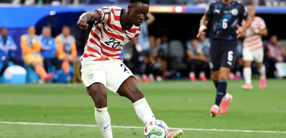 Player in USA kit kicking ball during match
