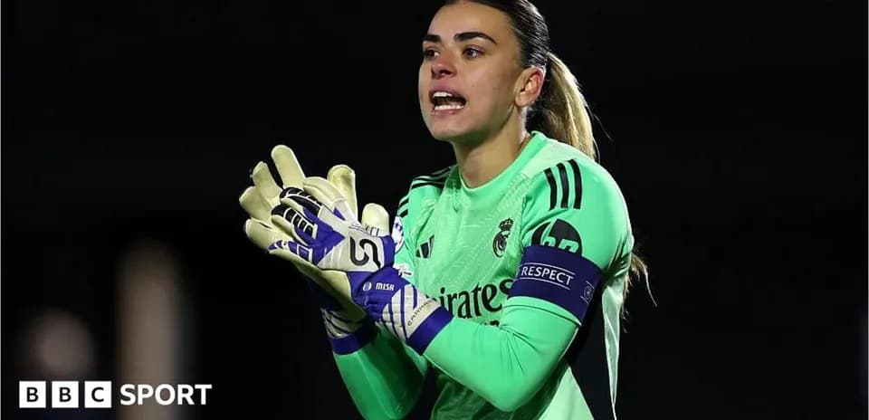 Goalkeeper in green kit directing teammates on field