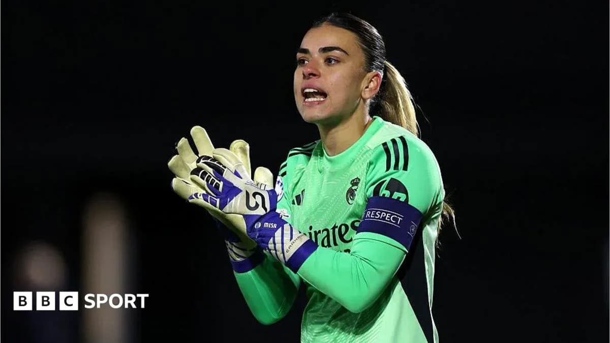 Goalkeeper in green kit directing teammates on field