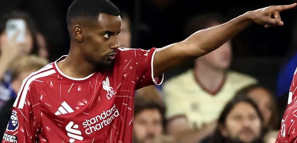 Player in Liverpool kit signaling during match