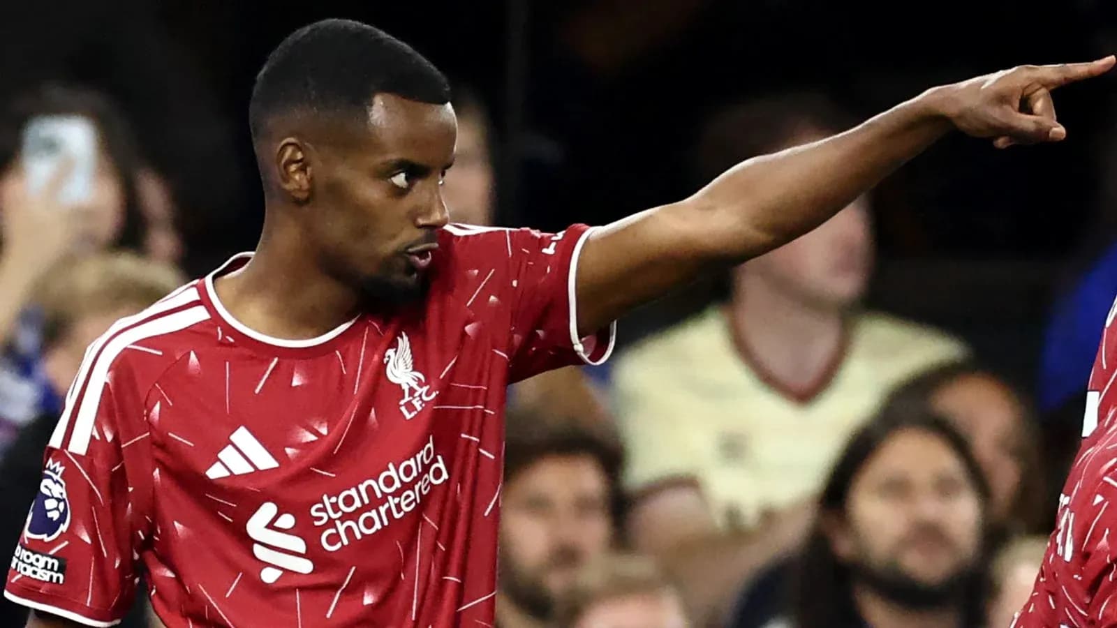 Player in Liverpool kit signaling during match