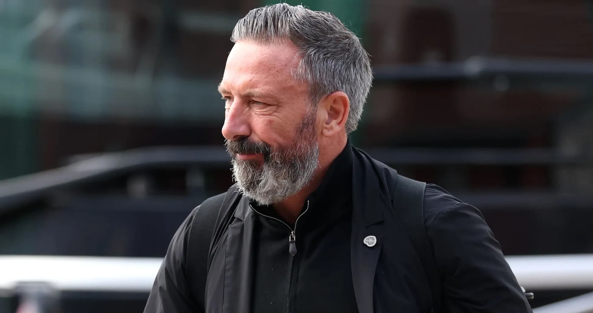 Man with beard walking near bus