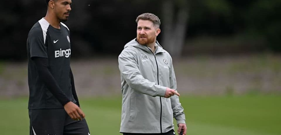 Player and coach walking on training pitch
