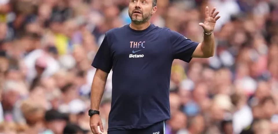 Coach gesturing during match in crowded stadium