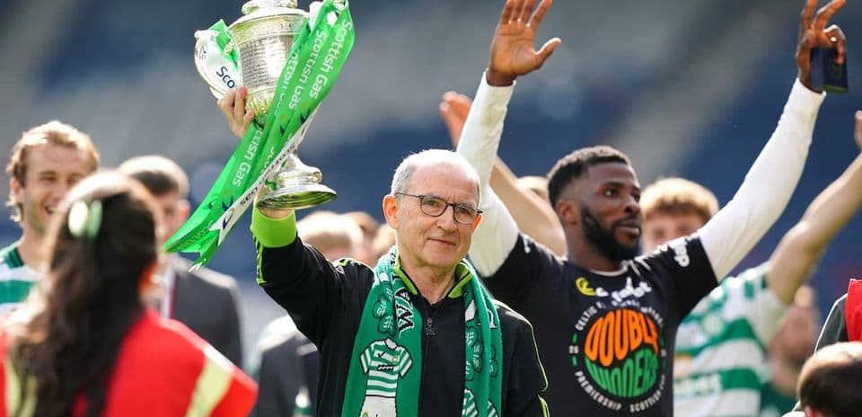 Man holding trophy with green ribbons, celebrating victory