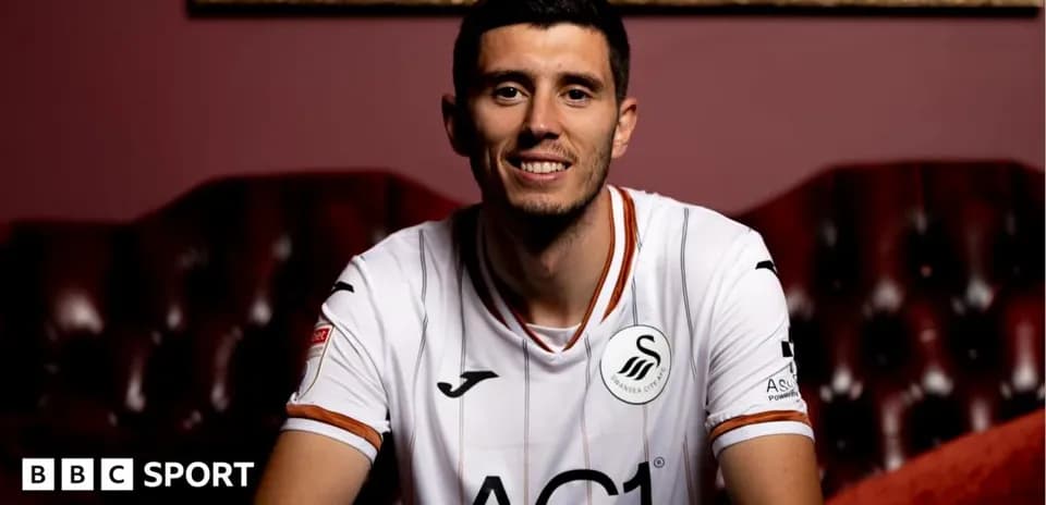 Player smiling in Swansea City jersey on couch