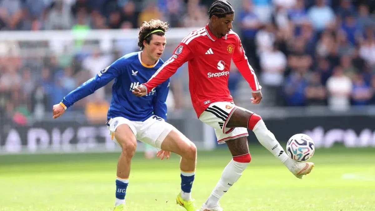 Player in red dribbling past opponent in blue
