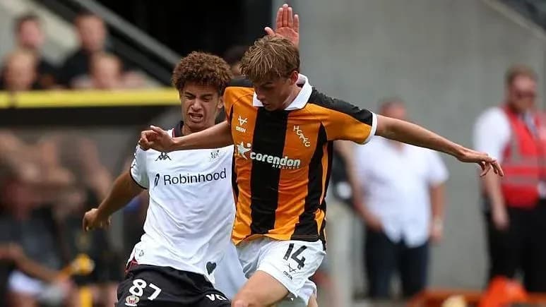 Player in black and white challenging player in orange