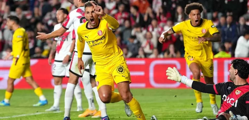 Player celebrating after scoring against the goalkeeper