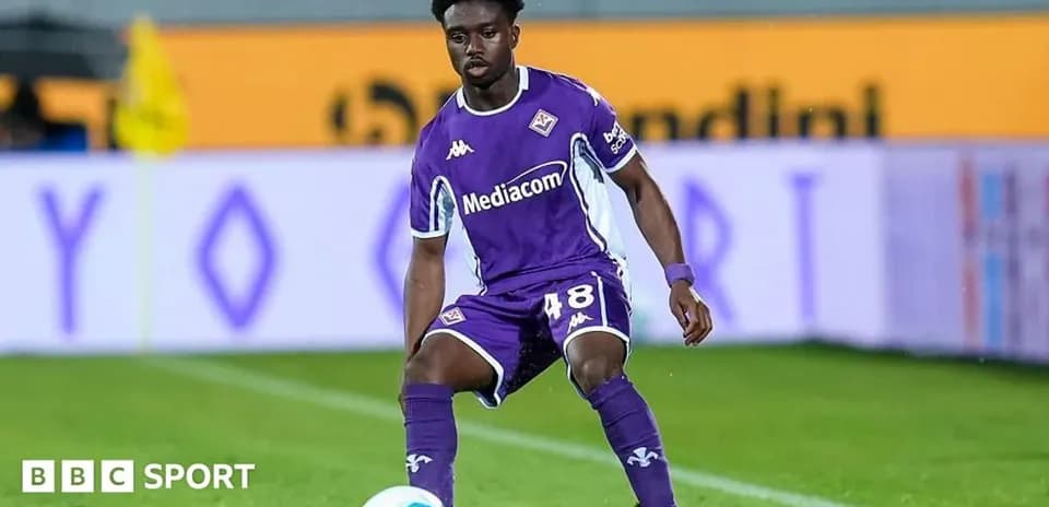 Player in purple jersey preparing to pass the ball