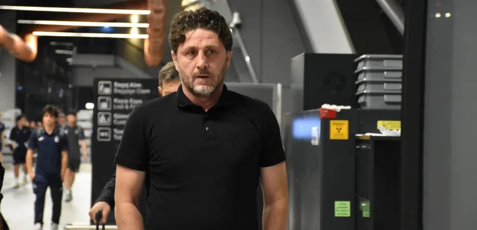 Coach walking through airport terminal with team