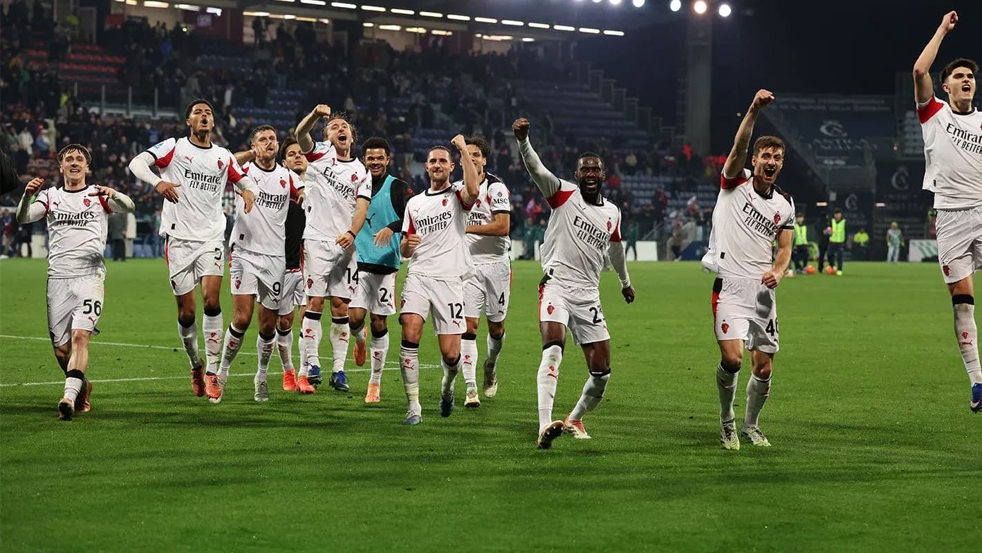 AC Milan players celebrating victory on the pitch AC Milan players celebrating victory on the pitch