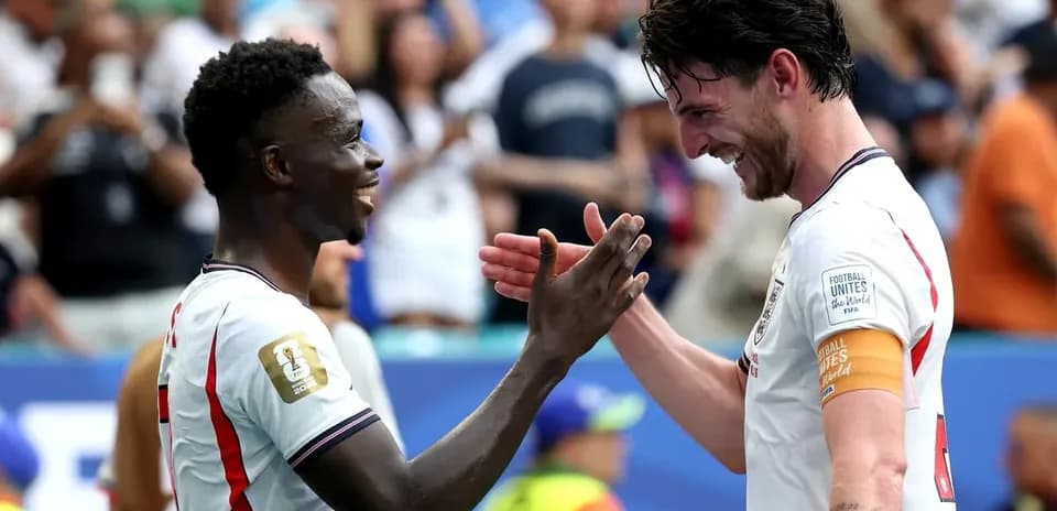 Two football players celebrating together on field