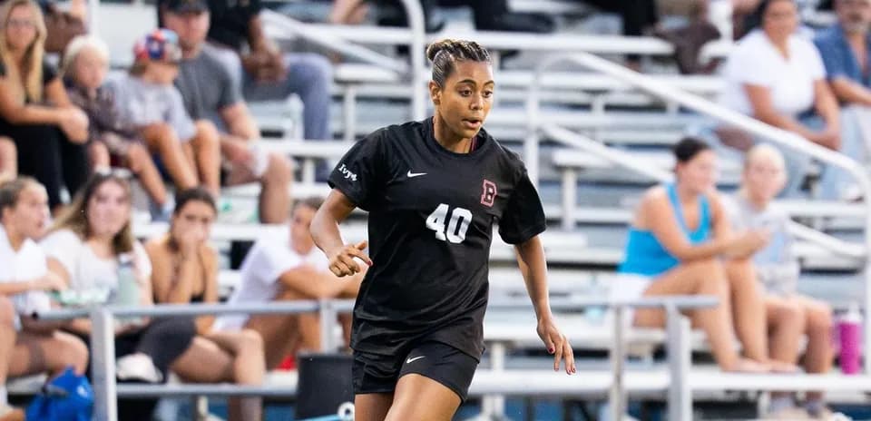 Soccer player in black uniform running on field