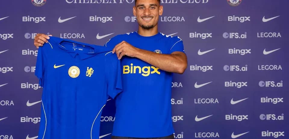 Player holding Chelsea jersey during press event