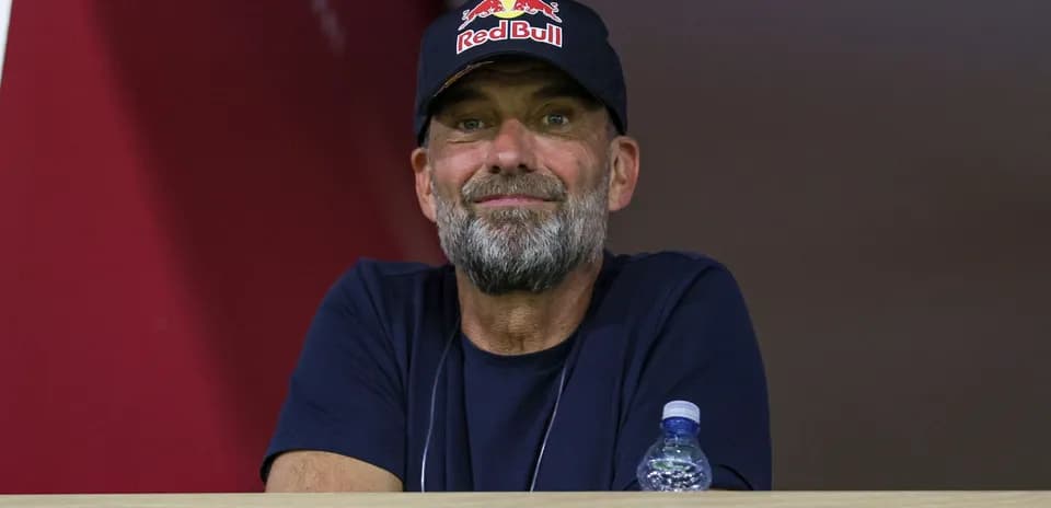 Man wearing Red Bull cap watching from a balcony