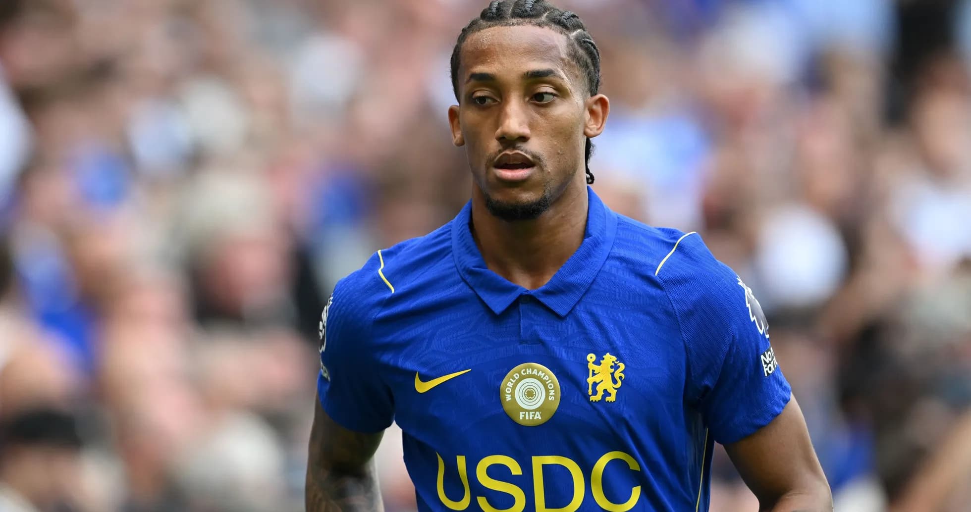 Player in blue Chelsea kit walking on the pitch