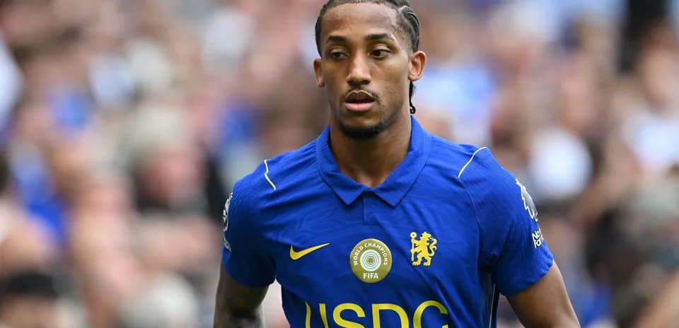 Player in blue Chelsea kit walking on the pitch