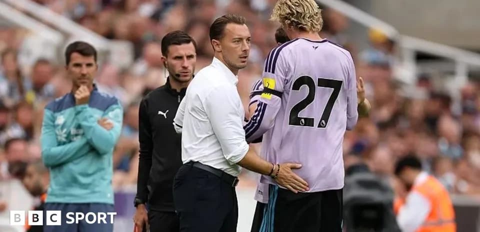 Coach discussing with goalkeeper during match substitution