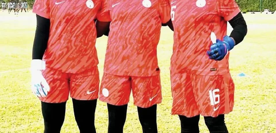 Three female football players posing in training kits