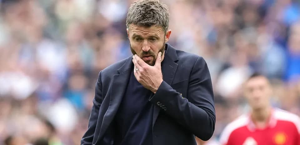 Coach in a suit pondering during a match