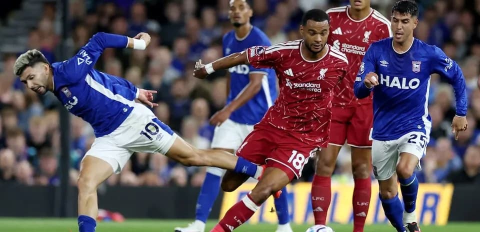 Ipswich player tackling Liverpool defender during match
