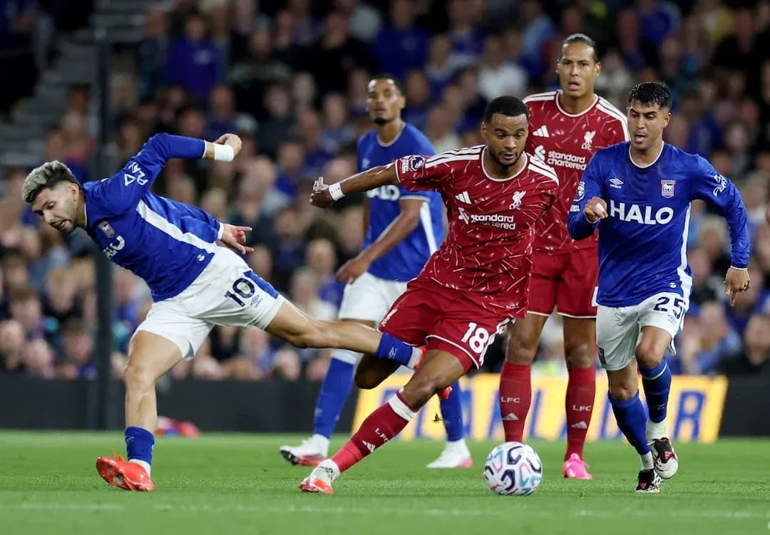 Ipswich player tackling Liverpool defender during match