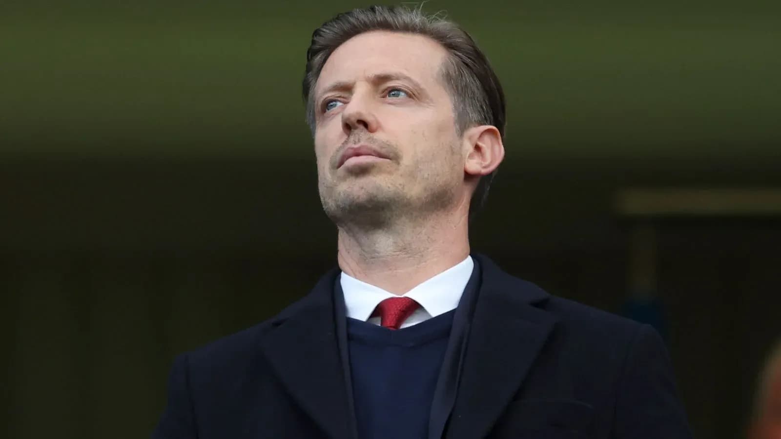 Man in suit observing from the stands