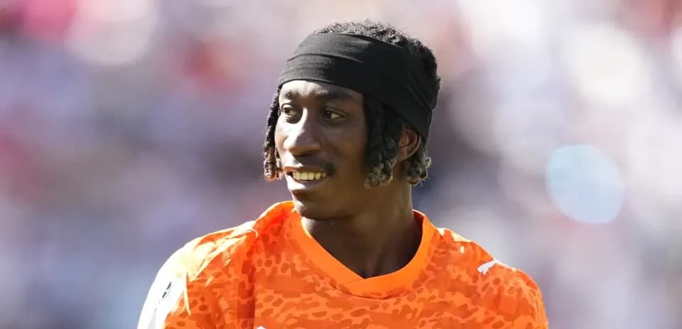 Goalkeeper in orange jersey during warm-up session