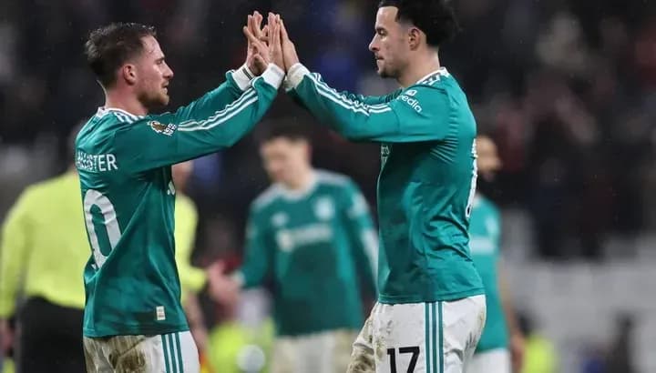 Two players celebrating with a high five on field