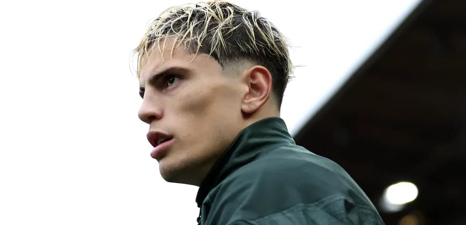 Player in green jacket looking away from camera