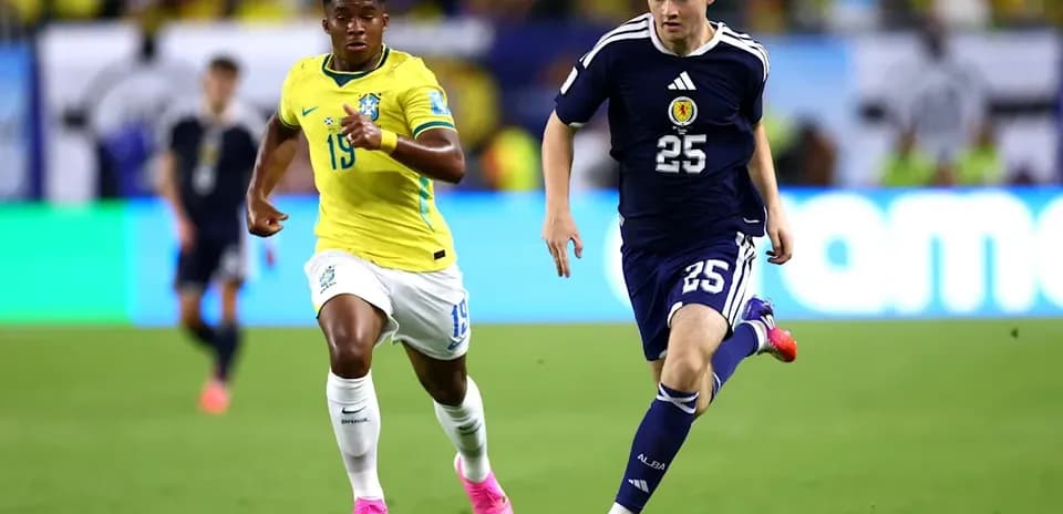 Player from Scotland sprinting with ball, Brazilian defender chasing