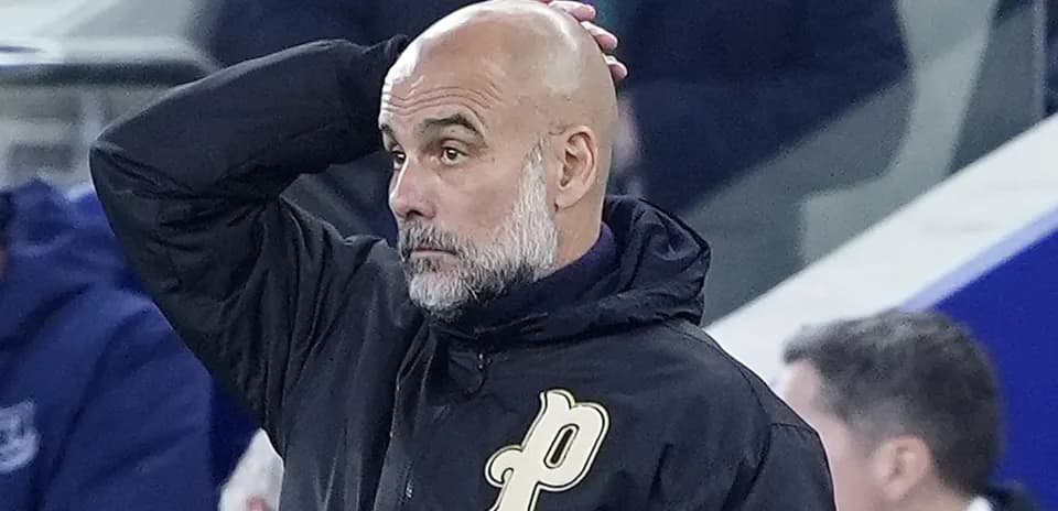 Coach with bald head looking concerned during match