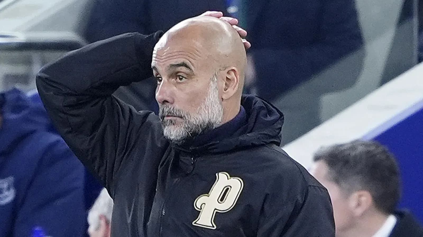 Coach with bald head looking concerned during match