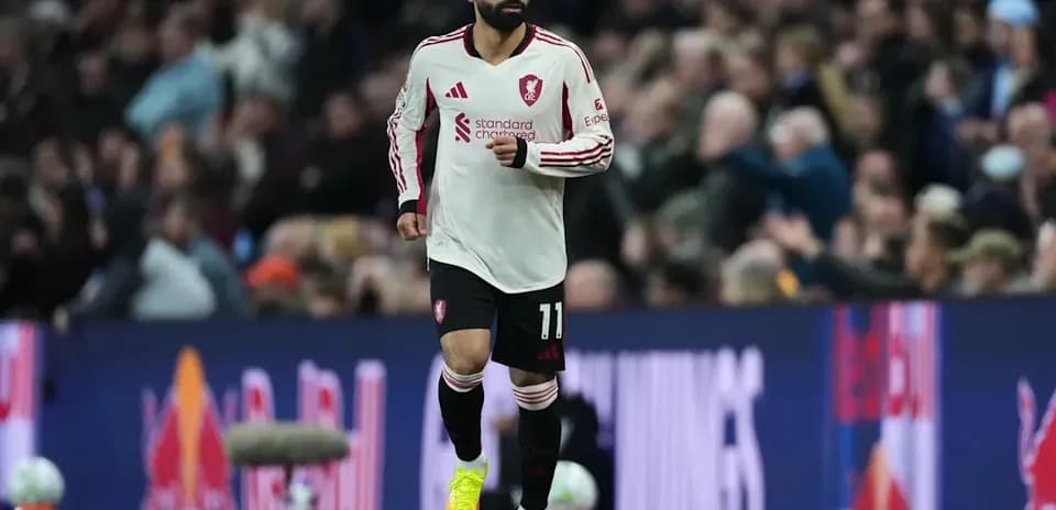 Player wearing Liverpool kit running on pitch