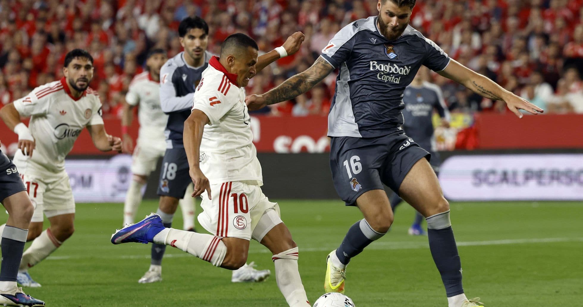 Sevilla player challenging Real Sociedad opponent