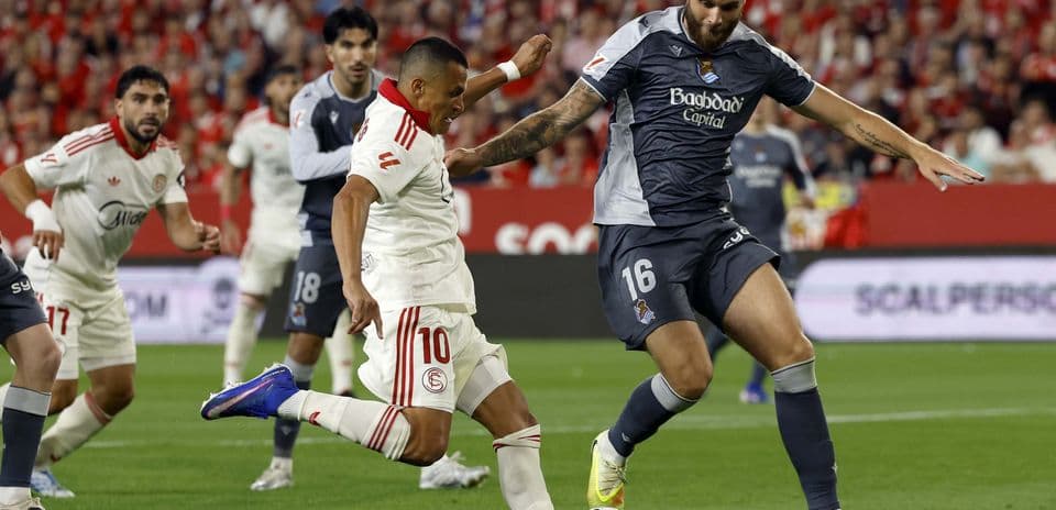 Sevilla player challenging Real Sociedad opponent