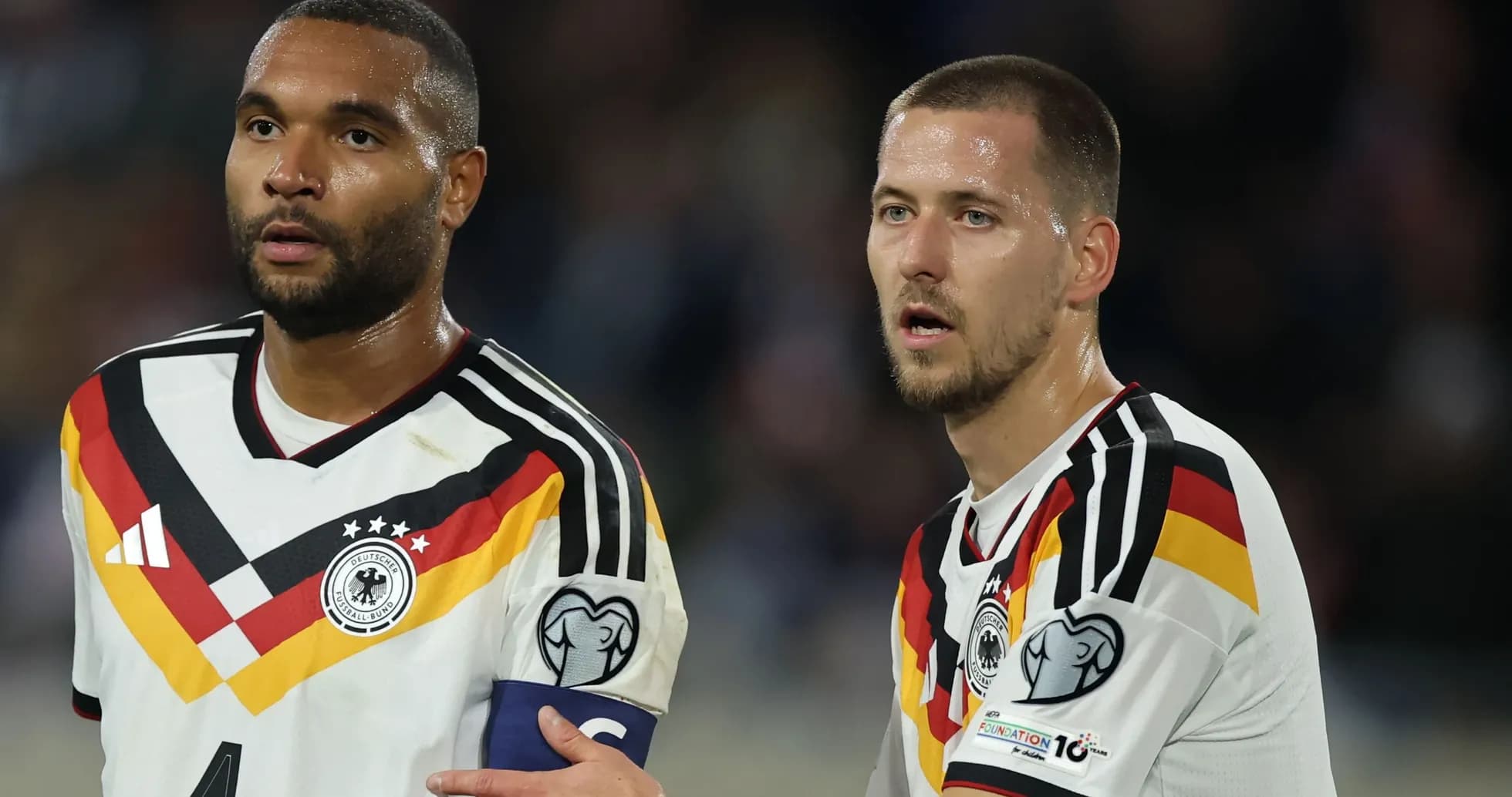 Two German players during a match, one wearing captain's armband