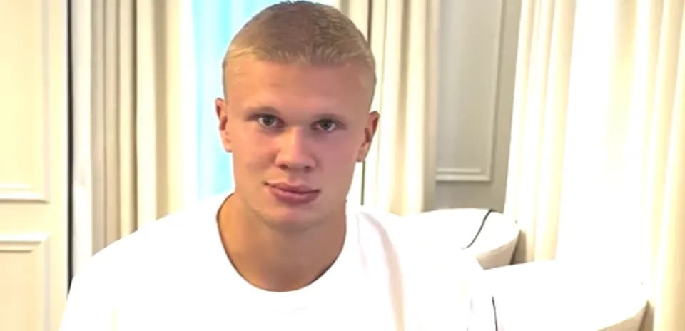 Young man sitting indoors wearing a white t-shirt