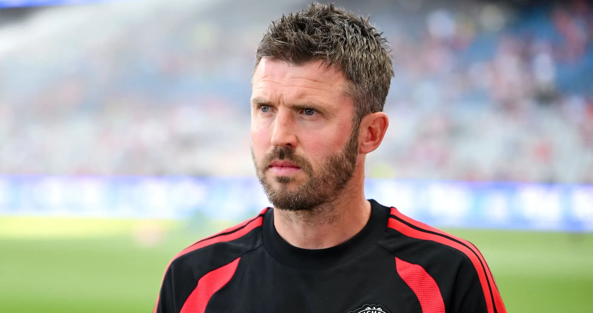 Coach in Manchester United training kit on field